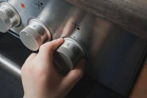 Hand Of A Child Switching On Stove Controls