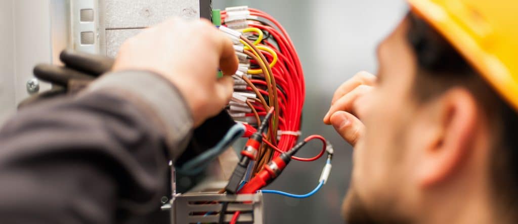 Electrician engineer tests electrical installations and wires on relay protection system. Bay control unit. Medium voltage switchgear