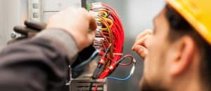Electrician engineer tests electrical installations and wires on relay protection system. Bay control unit. Medium voltage switchgear