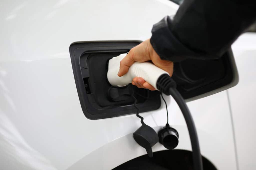 inserts electric charger into vehicle